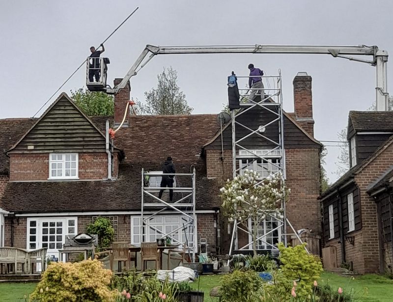 The Roof Moss Cleaners using cherry picker and scaffolding to clean roof safely and professionally in Frimley, Surrey
